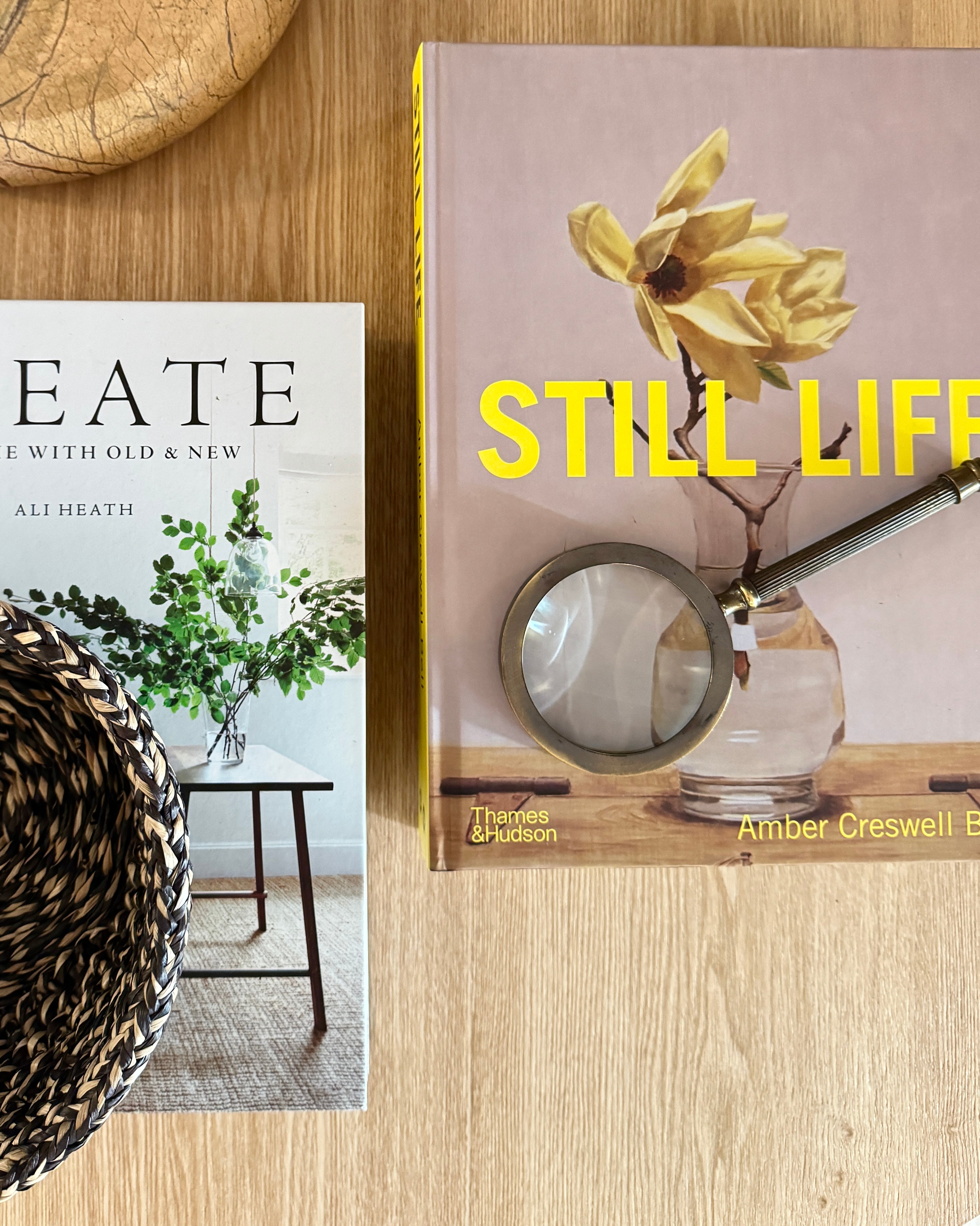 Medium brass magnifying glass by CC Interiors with a round handle and clear glass lens for detailed viewing.
