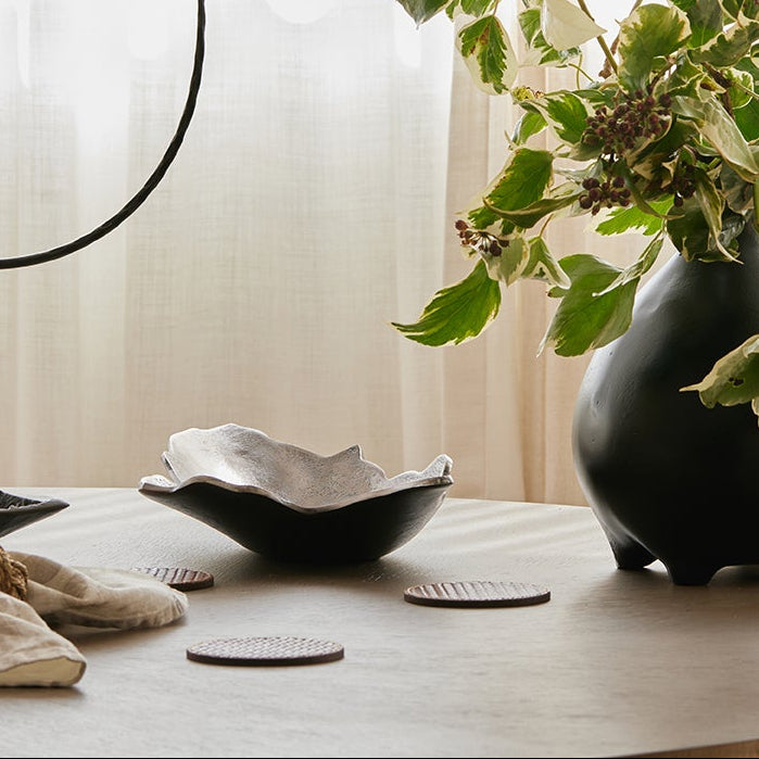 Black bowl and vase on a neutral background