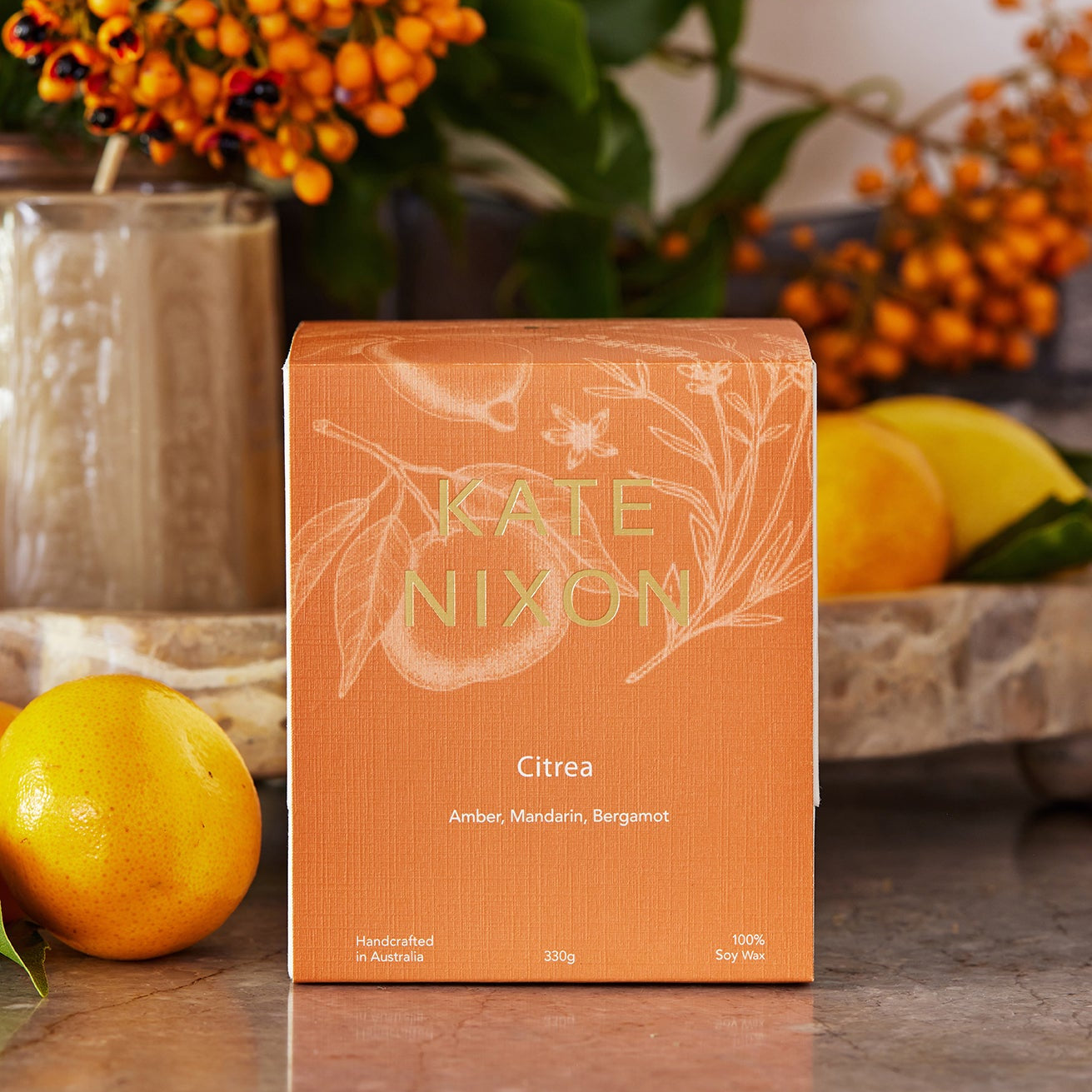 Orange box with 'Kate Nixon' branding on a table with decorative elements