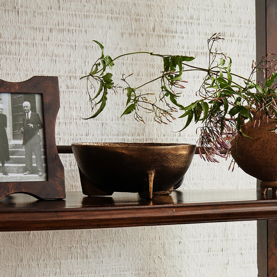 Wooden shelf with decorative items including books, a tissue box, and a black figurine.