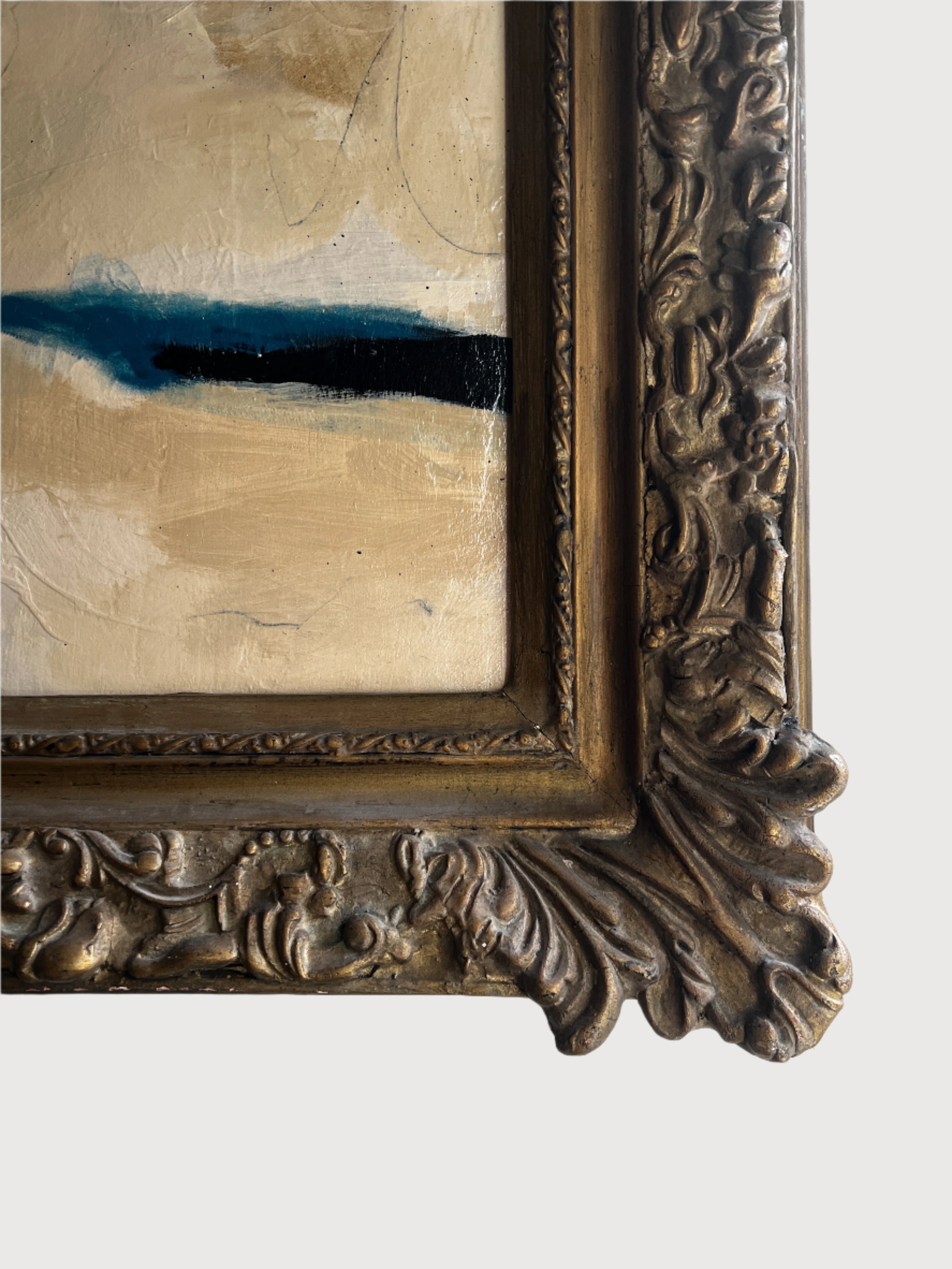 Close-up of a decorative gold frame with a painting inside on a white background