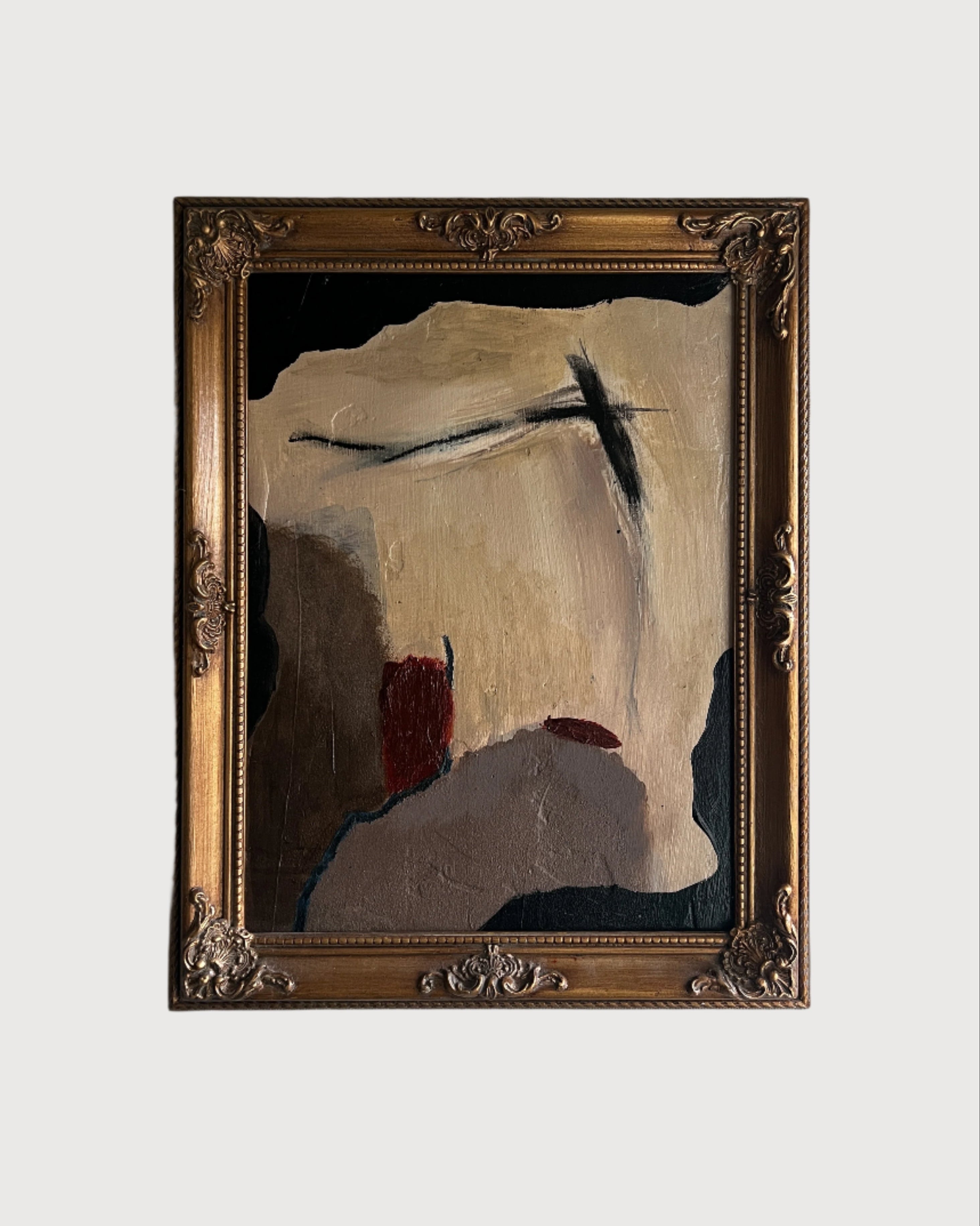 Abstract painting in a gold frame on a white wall