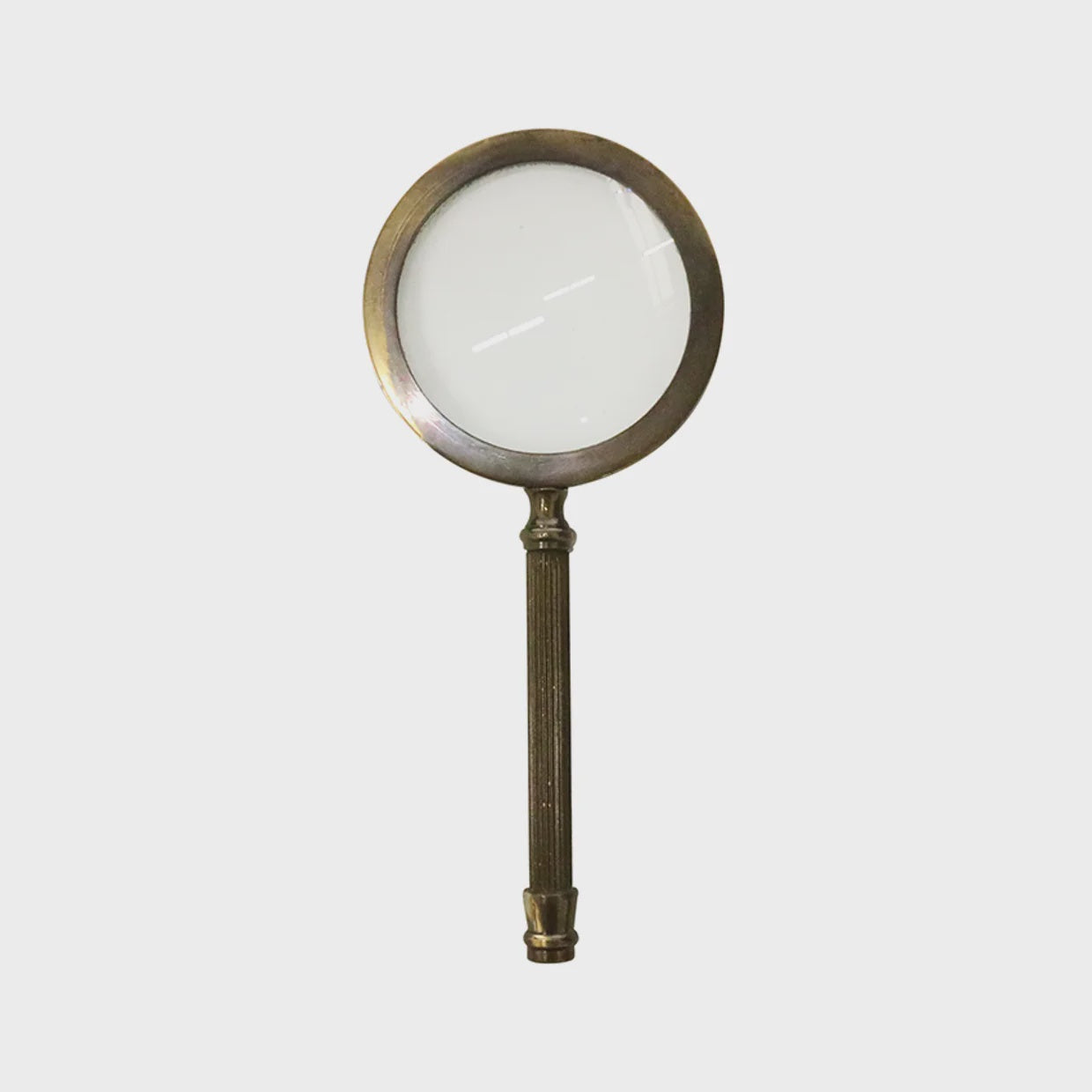 Medium brass magnifying glass by CC Interiors with a classic handle and clear glass lens, ideal for detailed viewing.