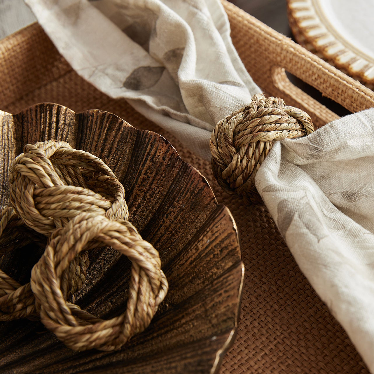 Decorative setting with woven elements and a white cloth on a wooden surface