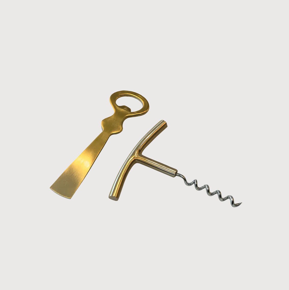 Brass corkscrew and bottle opener on a white background