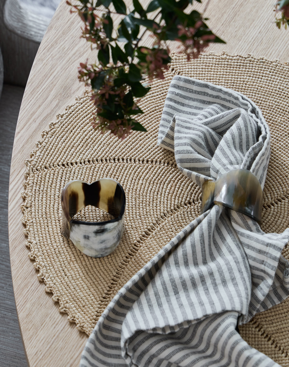 KATE NIXON HOME Petal napkin ring with sculpted floral design, shown on a folded table napkin