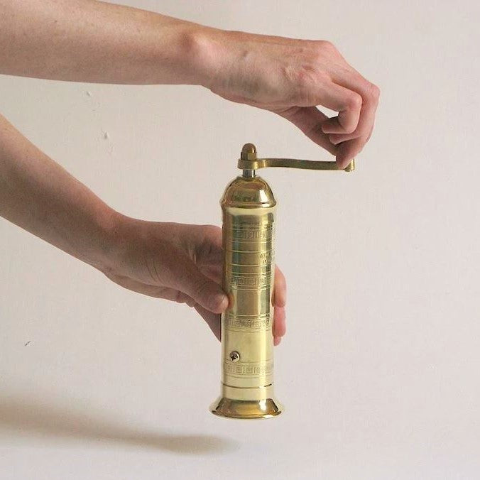 Brass pepper mill by Alexander Mills, stylish tableware with a polished finish, designed for grinding fresh pepper at the dinner table.