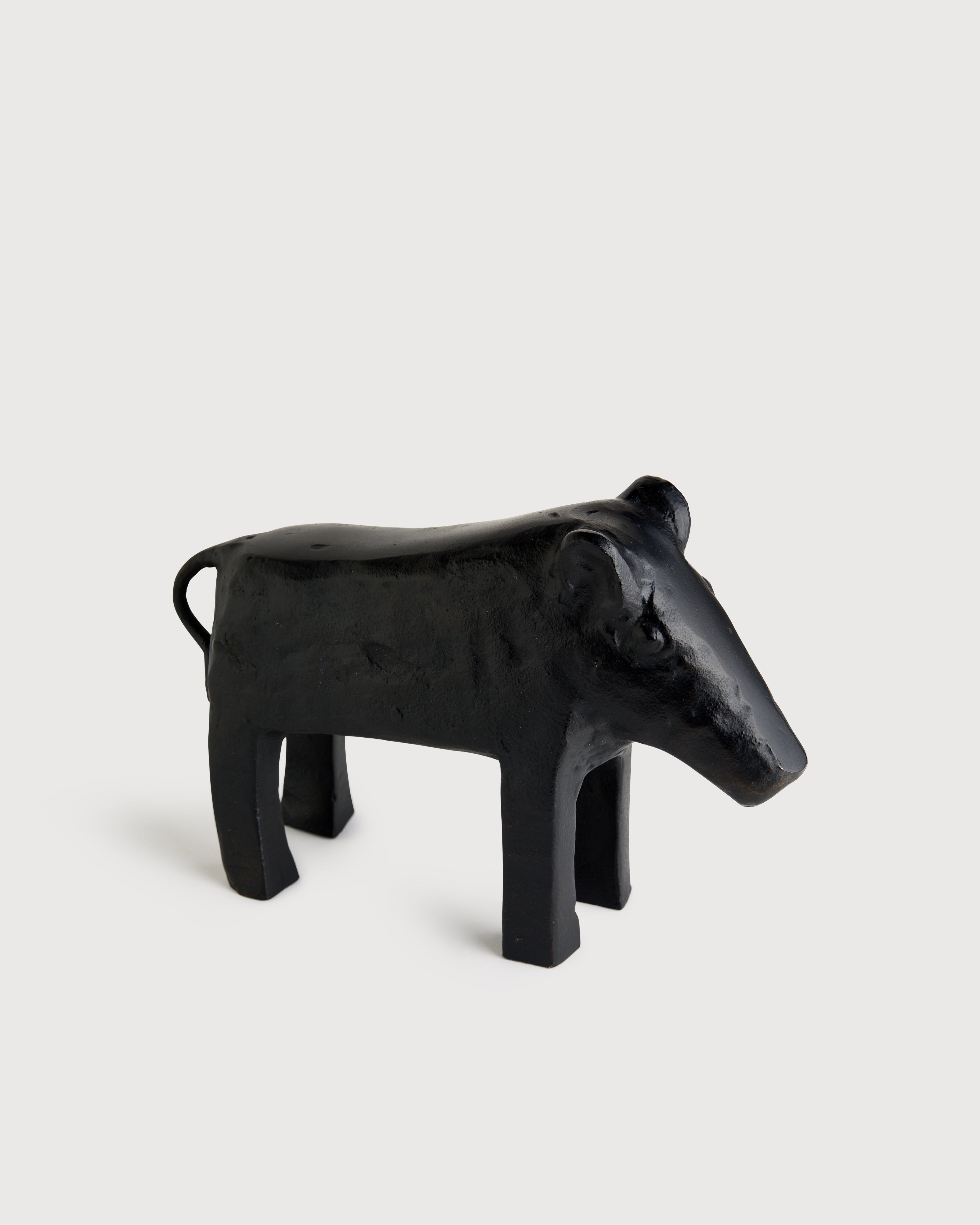 Black cow-shaped object on a white background