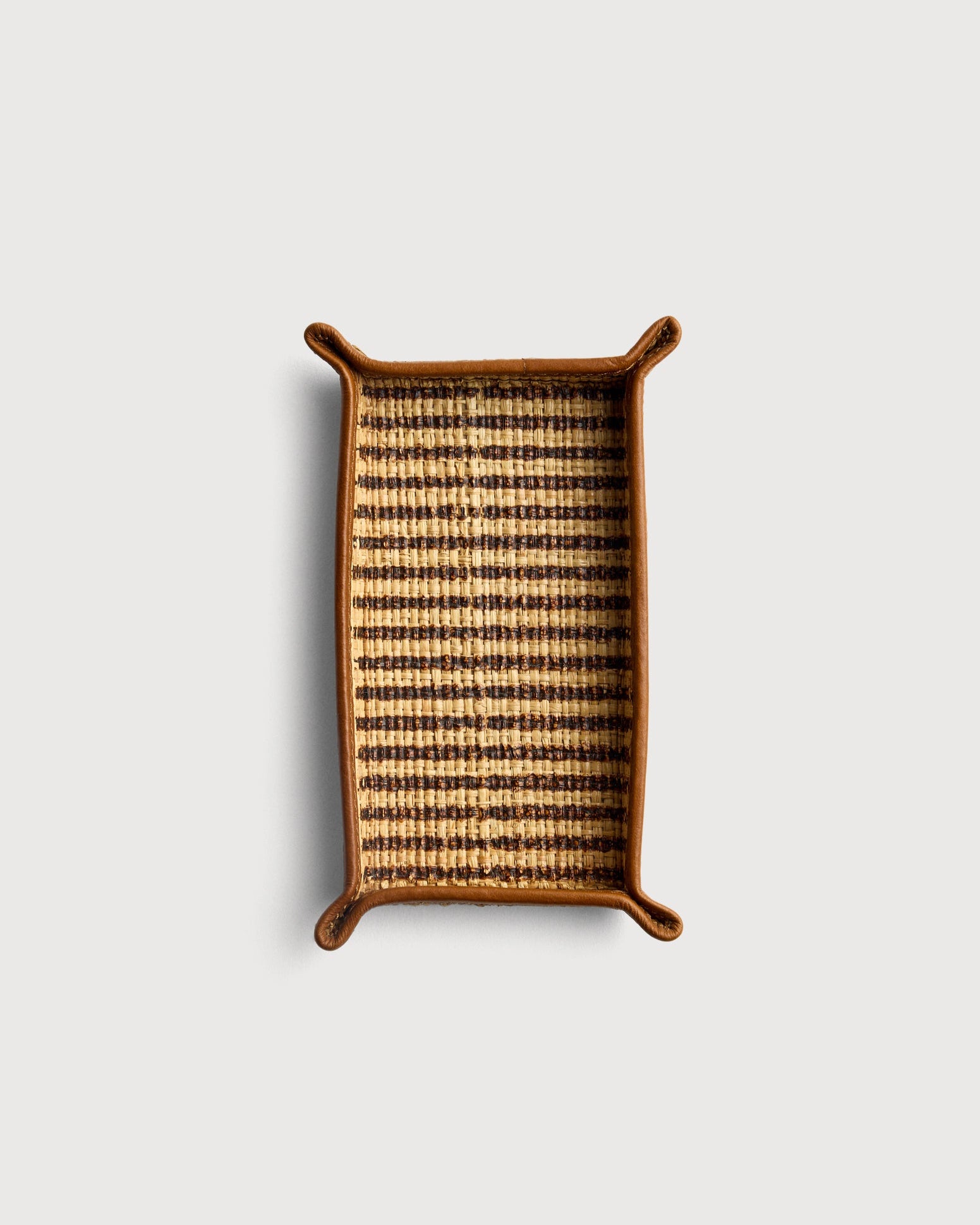 Rectangular woven tray with striped pattern on a light gray background